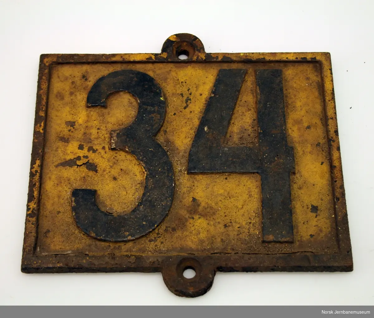 Støpt avstandsmerke med tallet "34".