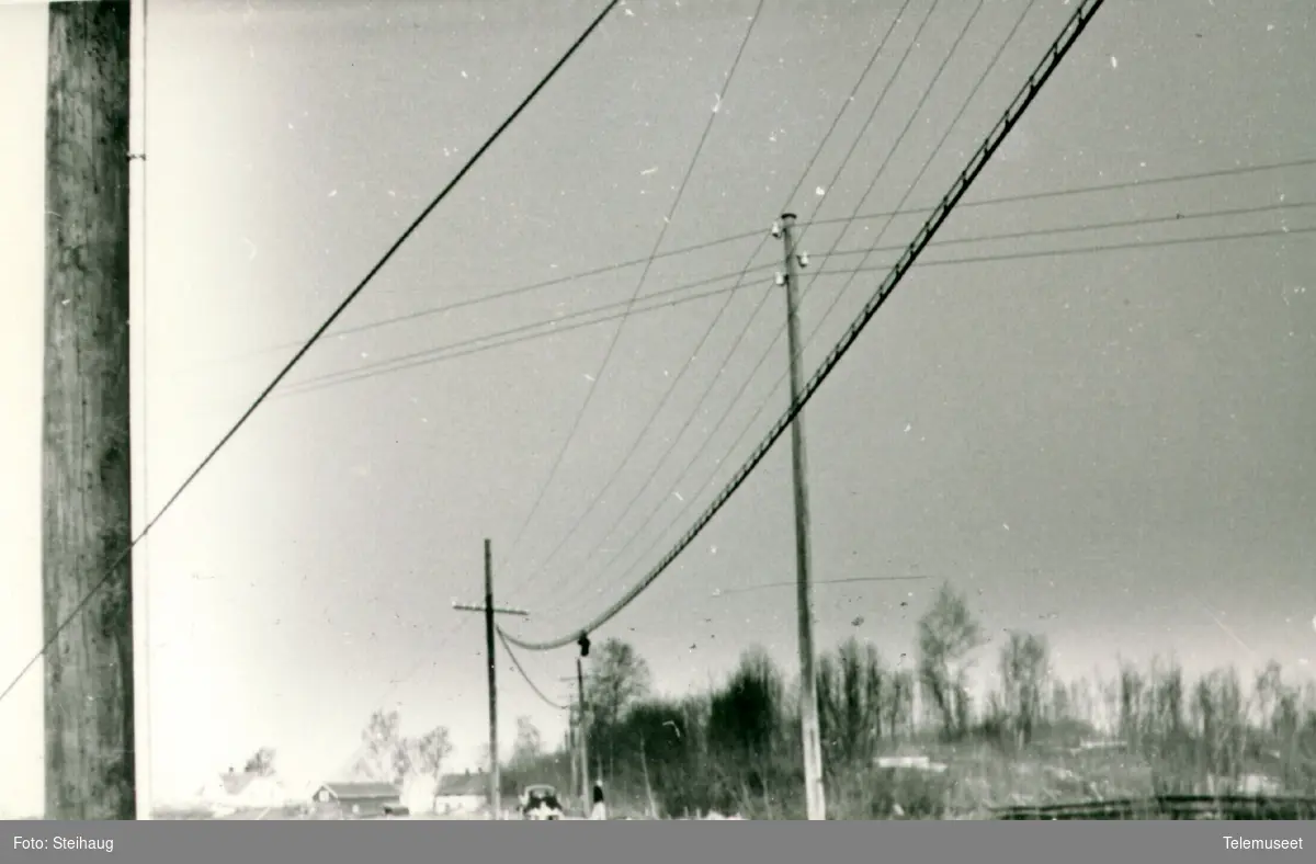 Linjekurser med luftkabel ved riksvegen litt syd for Ottestad sentral, sentralen i bakgrunnen, ca 1960