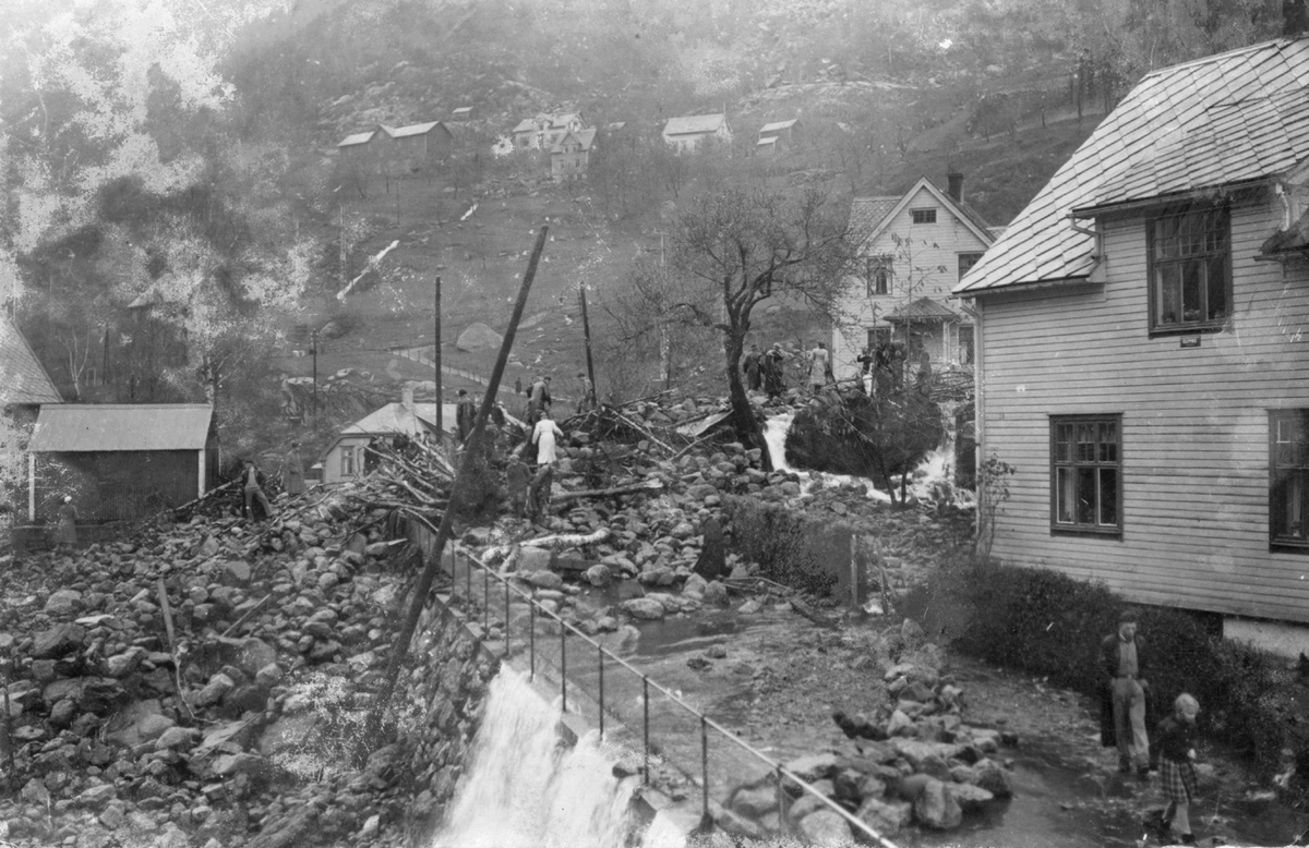 Folk sjår på skadane etter flaumen i Tyssedalsvegen 13.12.1938.  