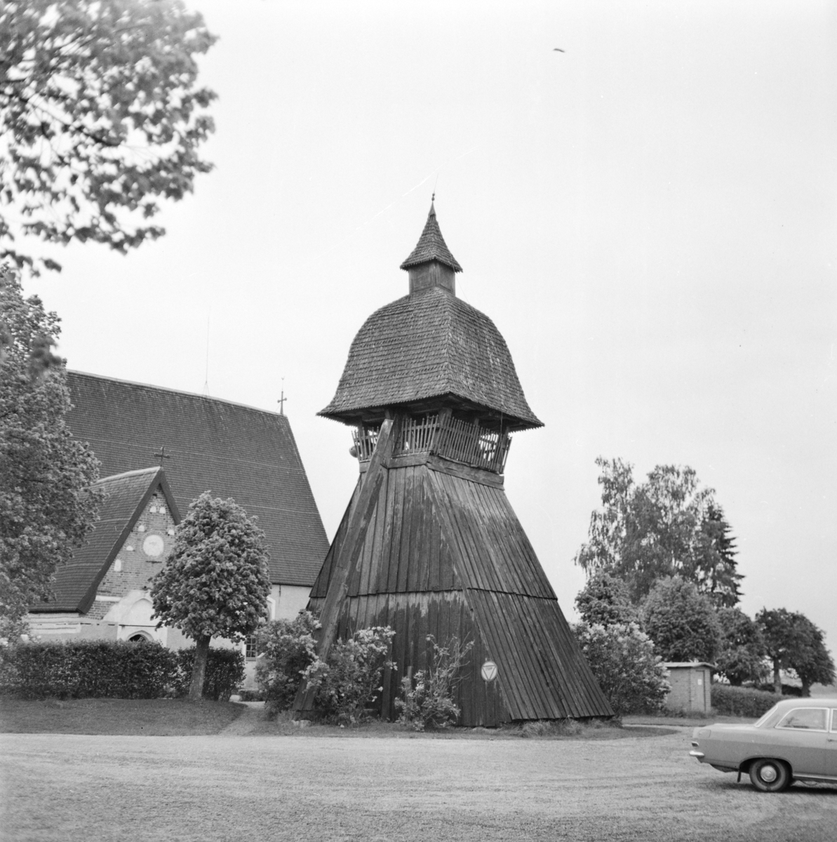 Klockstapel med Sparrsätra kyrka i bakgrunden, Uppland 1968