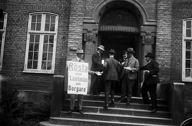 Män på väg in i en vallokal, en man med en skylt ”Rösta med lantmän och borgare” Johnsons privata bilder.