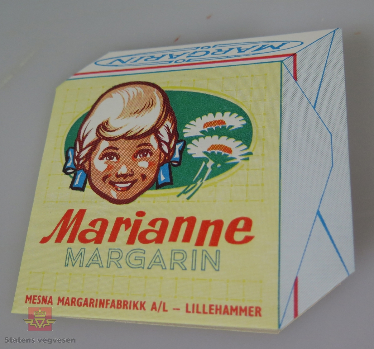 7 synåler og en nåletreder. Alt er festet til et brett av papp. Emballasjen (brettet) har reklame for Marianne Margarin fra Mesna Margarinfabrikk.