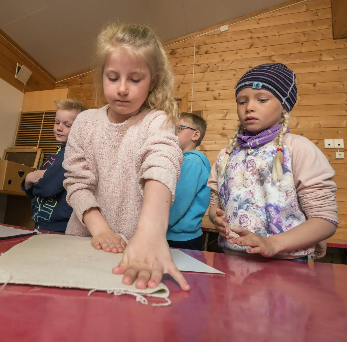 To barn stryker filt på håndlagd papir for å gjøre det glatt