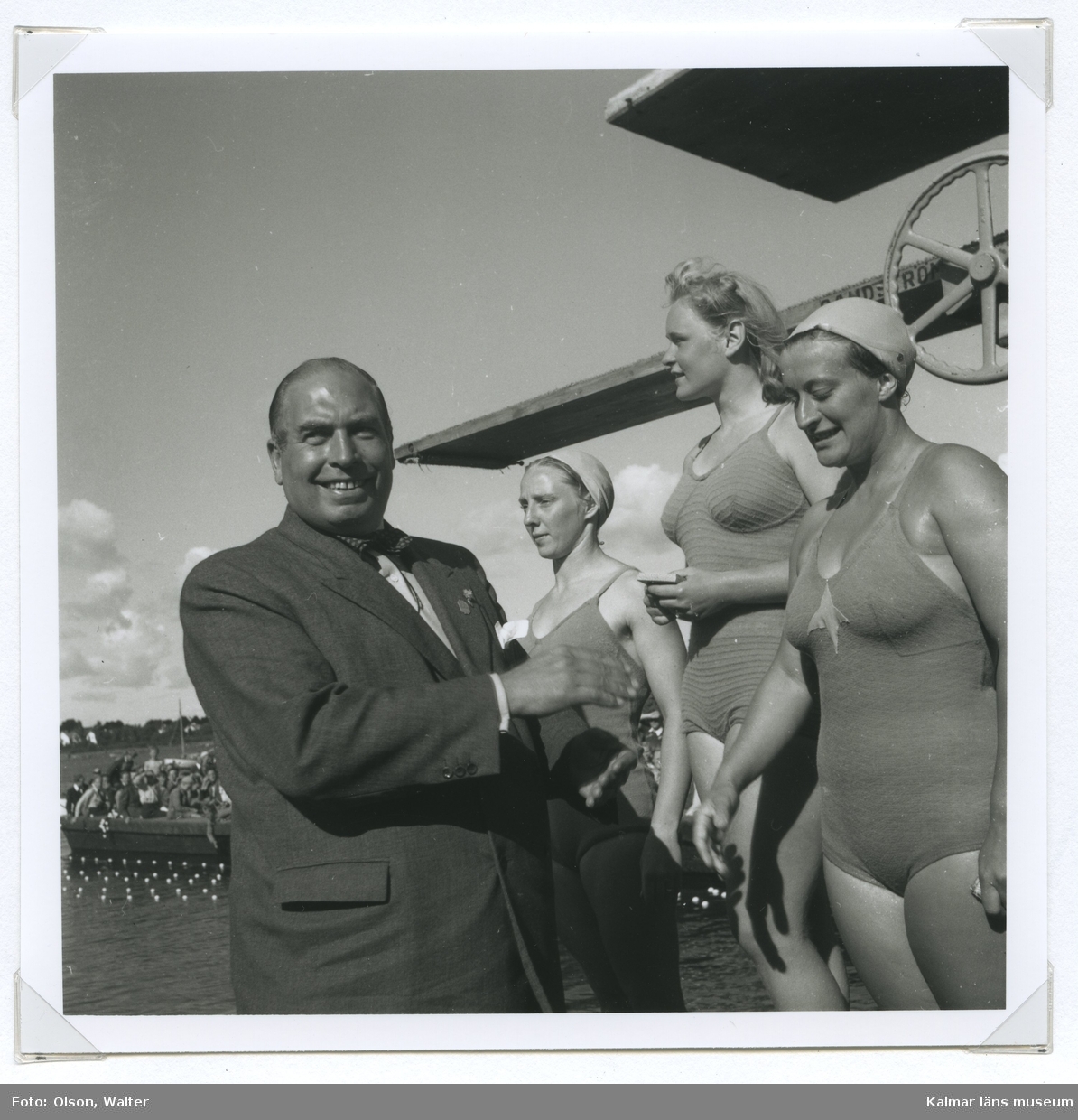 Från SM i simning, som 1946 hölls vid Långviksbadet i Kalmar. Nils Backlund premierar vinnarna i damernas svikthopp. Från höger trean Britt Walther, IFK Sthlm, ettan Mildred Netzel, SKK, och tvåan Eva Petersen, SHK.