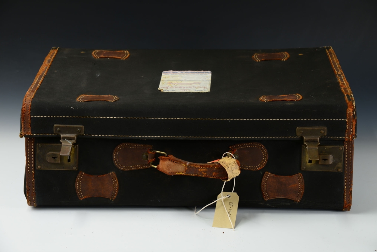Koffert med lås på sidene. Kofferten inneholder fire adskilte rom.