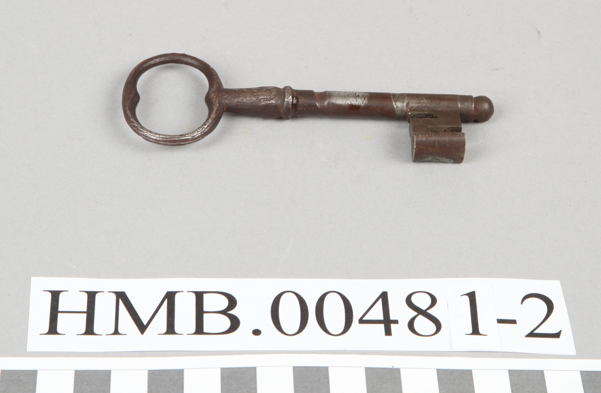 Nøkkel med ovalt hode og rund stamme. Det er et blankpusset område der nøkkelen har gått rundt i låsen.