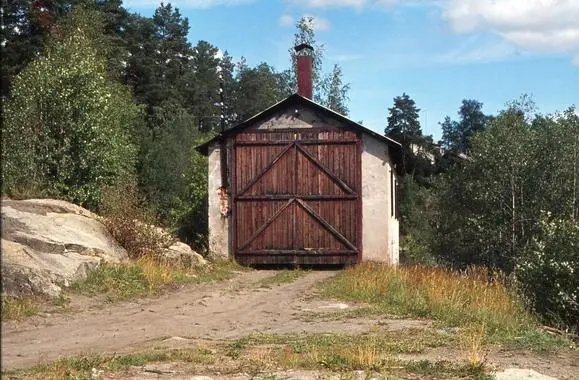 Gammel lokstall med store dører. Ble brukt til å lagre Caroline-toget på klevfos