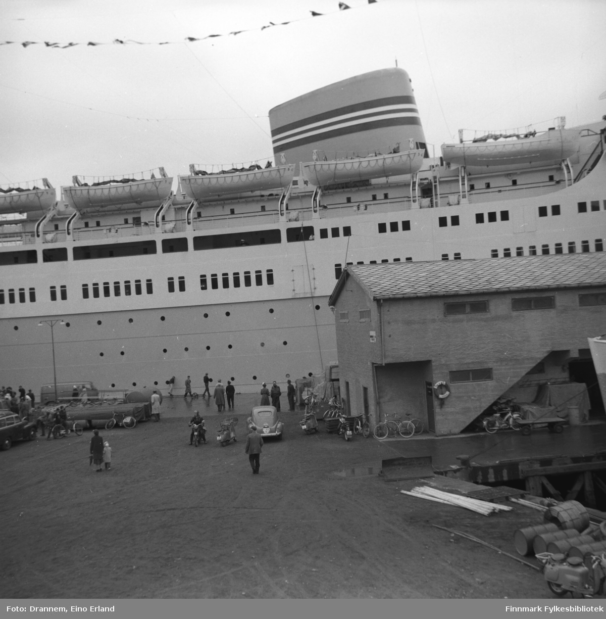 Ett stort passasjerskip ligger ved Dampskipskaia foran godsterminalen. Dette er  M/S Oslofjord, bygget i 1949 og tilhørte Den Norske Amerikalinje.
