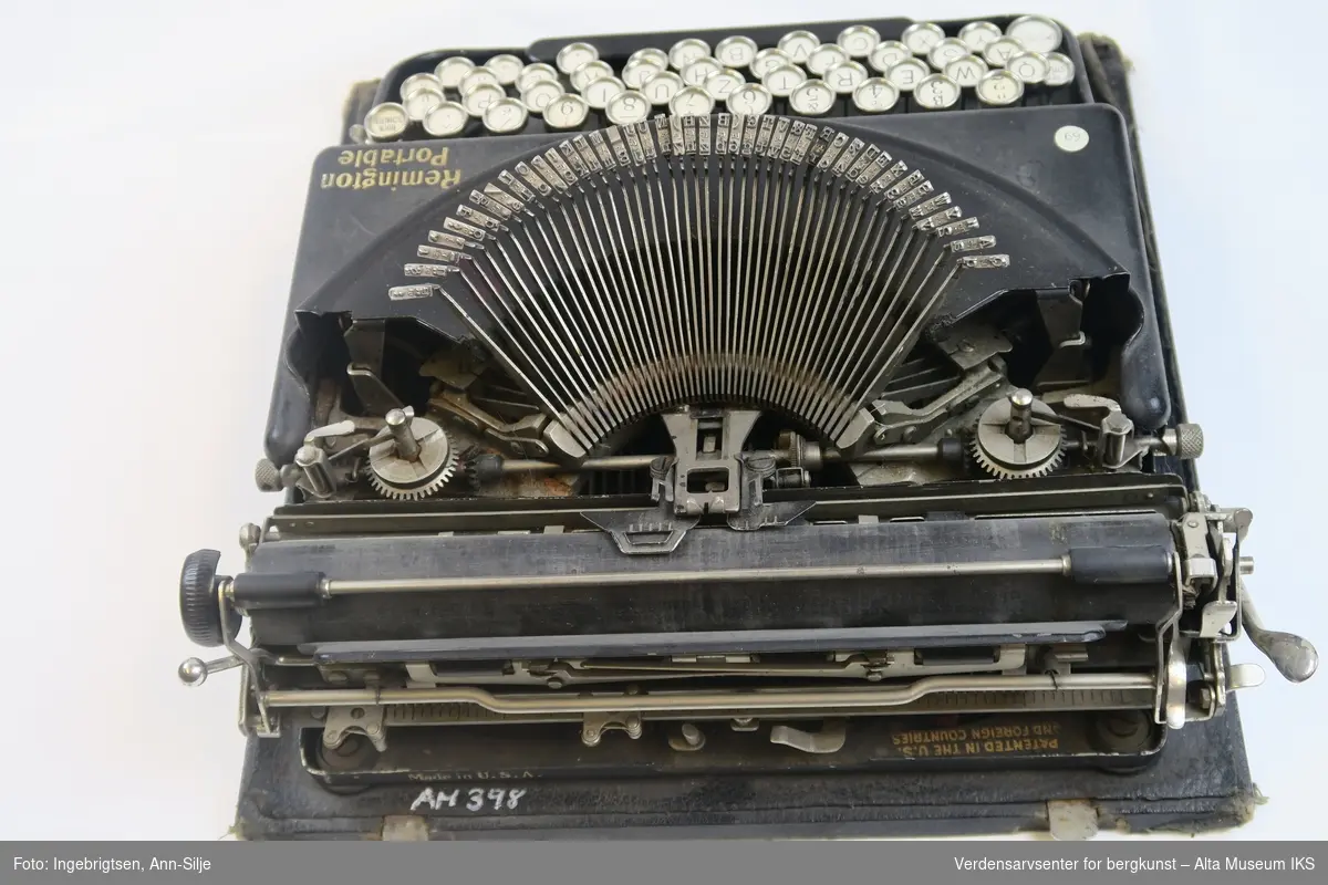 Sort skrivemaskin med hvite taster.