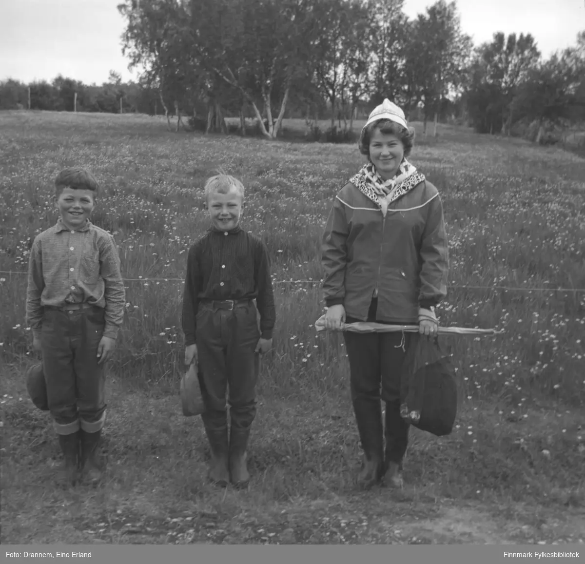 Tre barn fotografert på et jorde. Til venstre på bildet står Ingolf E. Eriksen,  i midten Ole Gabrielsen og til høyre står Turid Karikoski.