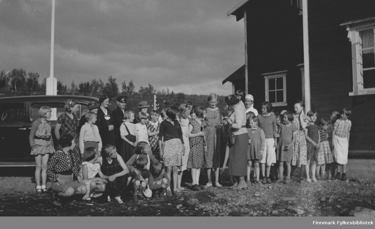 Sanitetsforenings feriekoloni i Repparfjord, fotografert 20.8.1936. Bak bildet en tekst: " Bananene deles ut".