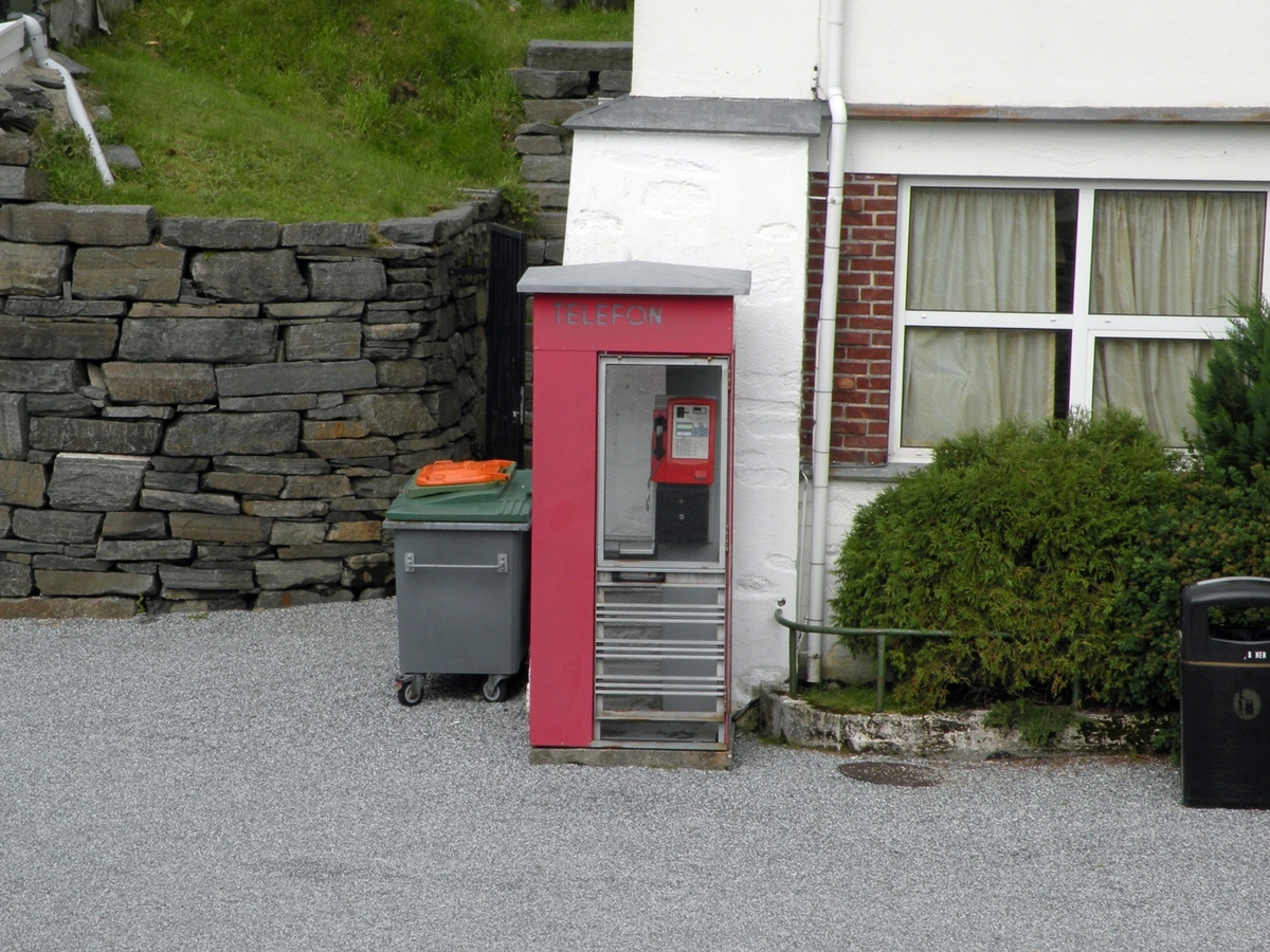 Telefonkiosken står ved Fløybanen i Bergen, og er en av de 100 vernede telefonkioskene i Norge. De røde telefonkioskene ble laget av hovedverkstedet til Telenor (Telegrafverket, Televerket). Målene er så å si uforandret. 
Vi har dessverre ikke hatt kapasitet til å gjøre grundige mål av hver enkelt kiosk som er vernet. 
Blant annet er vekten og høyden på døra endret fra tegningene til hovedverkstedet fra 1933.
Målene fra 1933 var:
Høyde 2500 mm + sokkel på ca 70 mm
Grunnflate 1000x1000 mm.
Vekt 850 kg.
Mange av oss har minner knyttet til den lille røde bygningen. Historien om telefonkiosken er på mange måter historien om oss.  Derfor ble 100 av de røde telefonkioskene rundt om i landet vernet i 1997. Dette er en av dem.