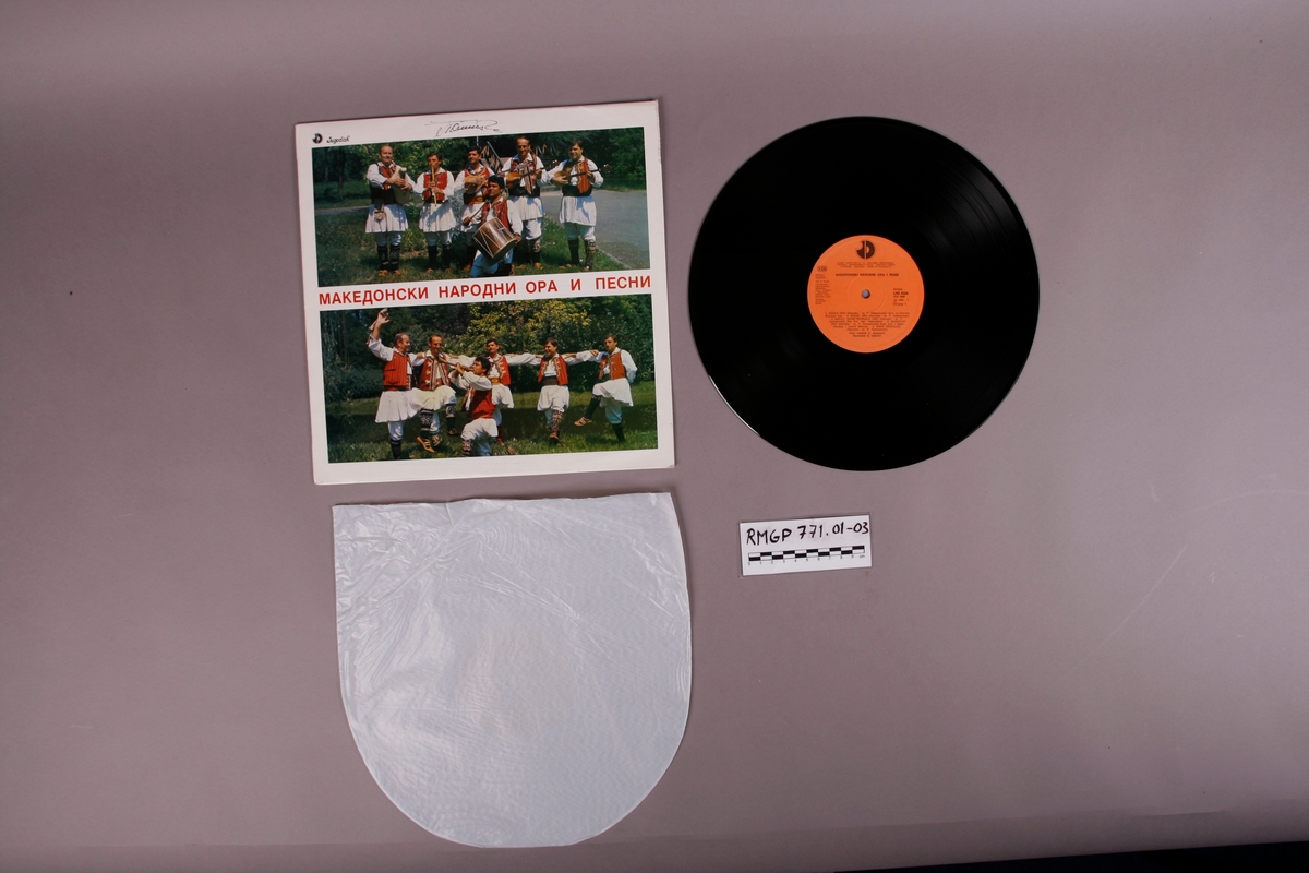 Grammofonplate i svart vinyl og plateomslag i papp. Plata ligger i en plastlomme. Tittel oversatt til norsk er "Makedonske folkedanser og sanger".