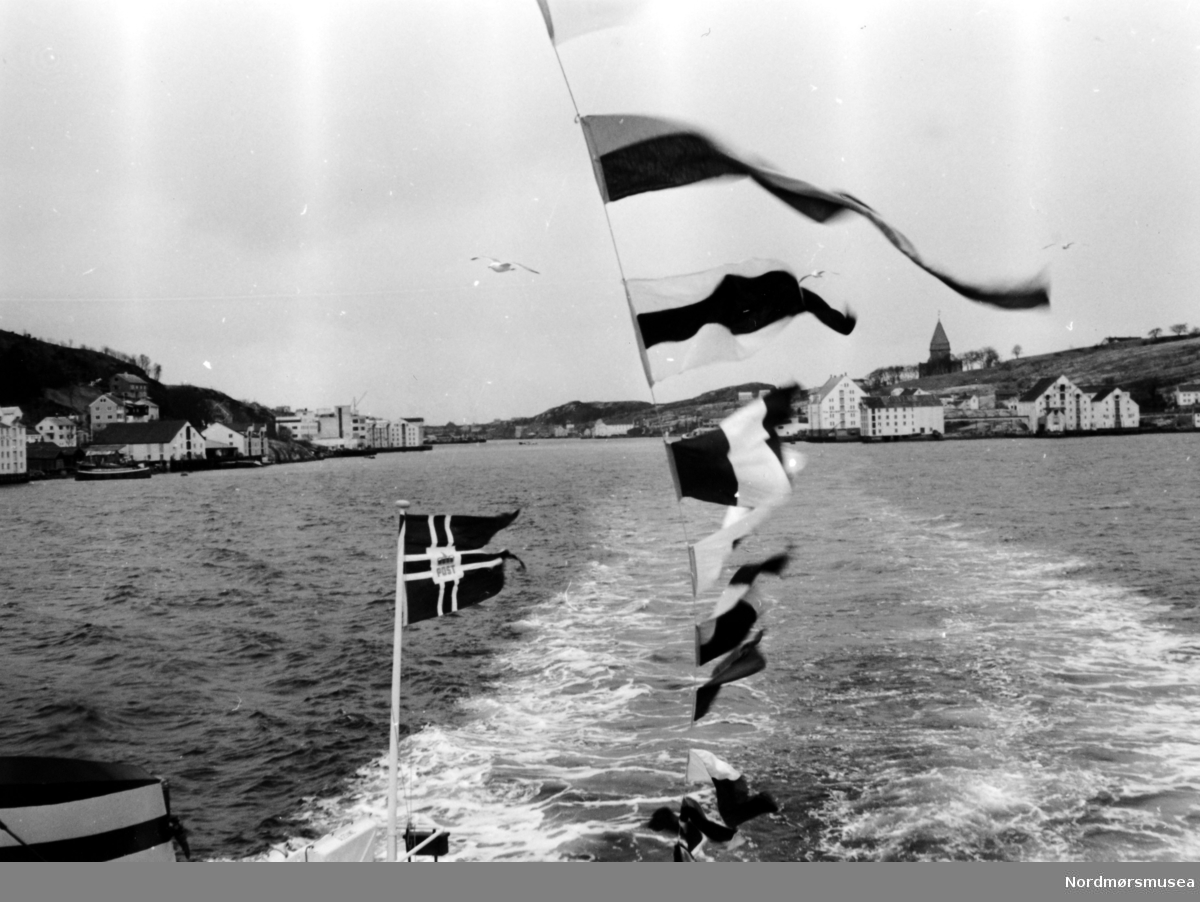 Bilferga Norddalsfjord, Storvik mek, bygg nr 14, på overleveringstur på Bolgsvaet. På vei ut til Bolgsvaet via Markussundet i bakgrunnen. Til venstre ser vi Innlandet og til høyre Nordlandet. Legg merke til postflagget. Se også bilde KMb-1983-031.0146.jpg. Fra Nordmøre Museums fotosamlinger.