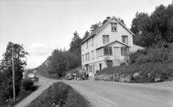 En lastebil og en bil er parket foran en bygning med butikk 