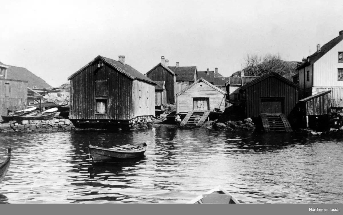 Naust og pakkhus i Hønebukta på Innlandet i Kristiansund. Fotograf er trolig Georg Sverdrup, og datering er sannsynligvis fra perioden 1930 til 1939. utedo, lunnstige, robåt, sjø
 Fra Nordmøre Museums fotosamlinger.
