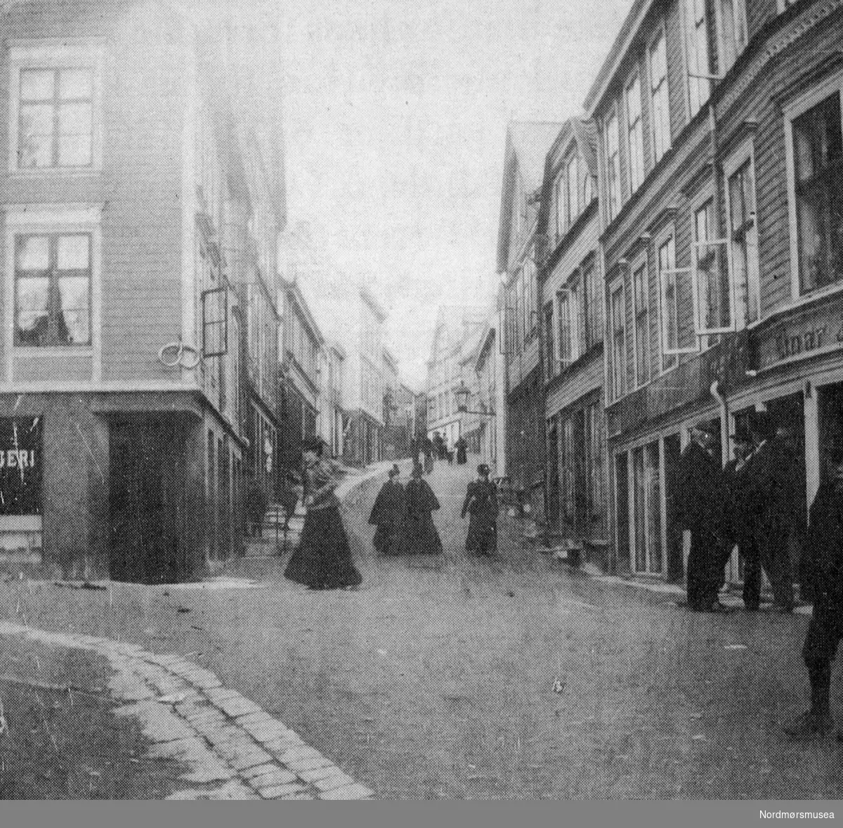 Søstrene Caroline (gift Knudtzon), Anna og Hilda Werring spaserer foran dr Werrings hus i Hauggt 12 (m/parafinlykt) ca 1895. (Fra Nordmøre Museums fotosamling)