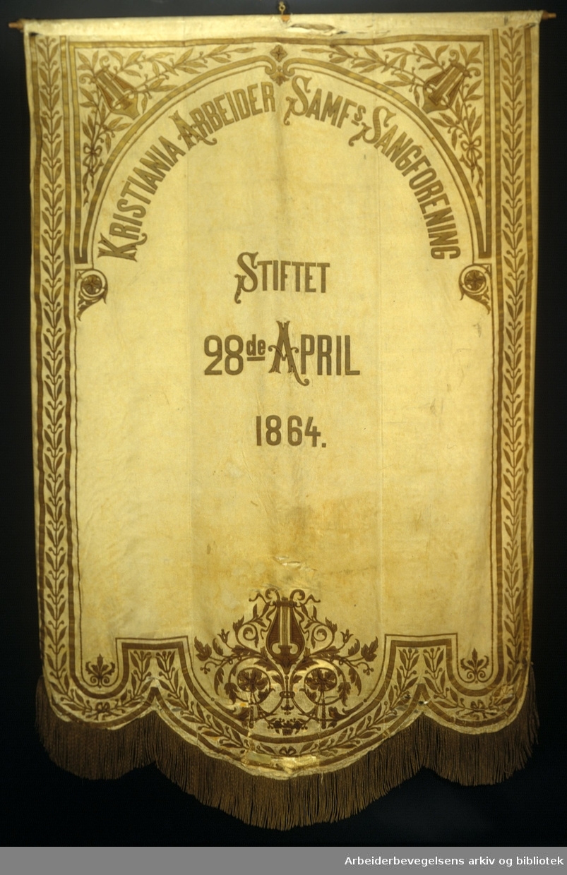Kristiania arbeidersamfunds sangforening.Stiftet 28. April 1864..Bakside..Fanetekst:.Kristiania Arbeider Samf`s Sangforening.Stiftet 28de April 1864.