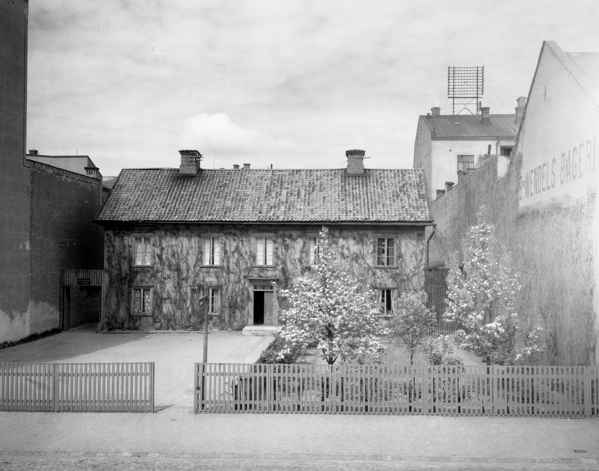 Bilden visar före detta gästgiverigården på Drottninggatan 20. Tomten bröt av mot gatans jämna husrad ända fram till rivningen 1959. Bilden togs 1934.
