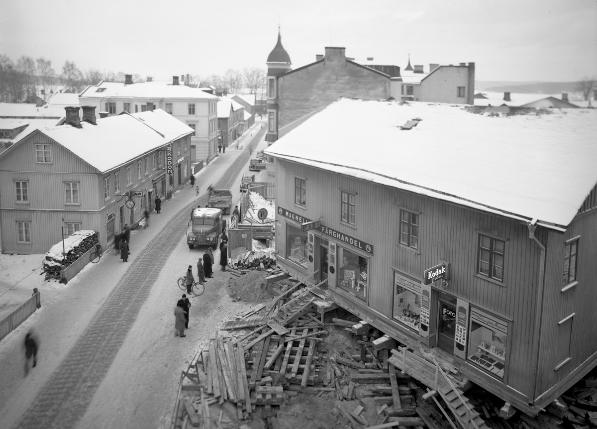 En affärsfastighet längs Kyrkogatan vrids och flyttas en bit ner på Hantverksgatan i oktober 1953.