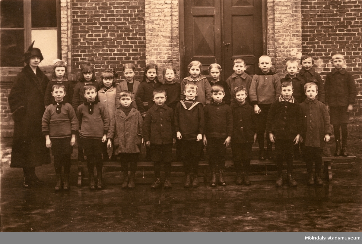 Lärarinnan Agda Carlson med småskoleklass vid Grevedämmets skola i Mölndal på 1920-talet.

För mer information om bilden se under tilläggsinformation.