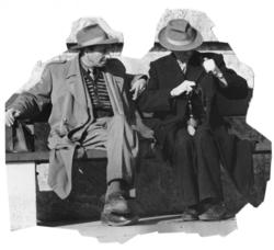 To eldre menn sitter på en parkbenk