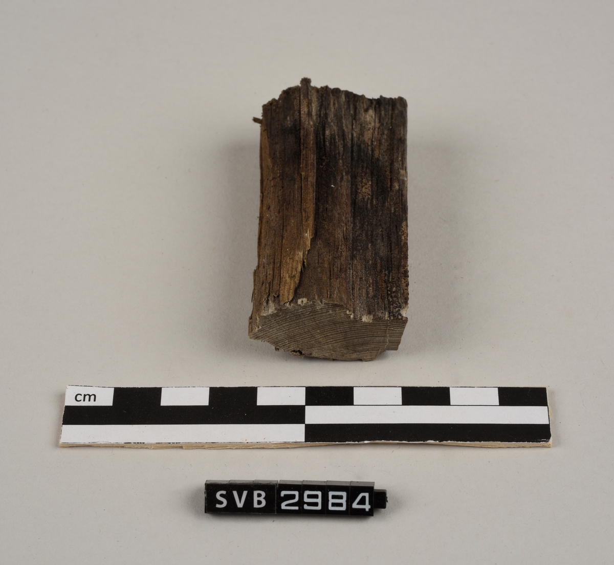 Tregjenstand med tilnærmet rundt tverrsnitt. Tremateriale er tørt og sprukkent. Det er 2 løse deler. Det er en lapp på undersiden med russiske tall og bokstaver.