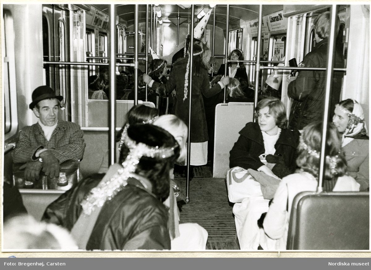 Luciavaka natten och morgonen 13 december 1973.
Luciafirande ungdomar blandas med andra resenärer på tunnelbanan i morgontrafiken.