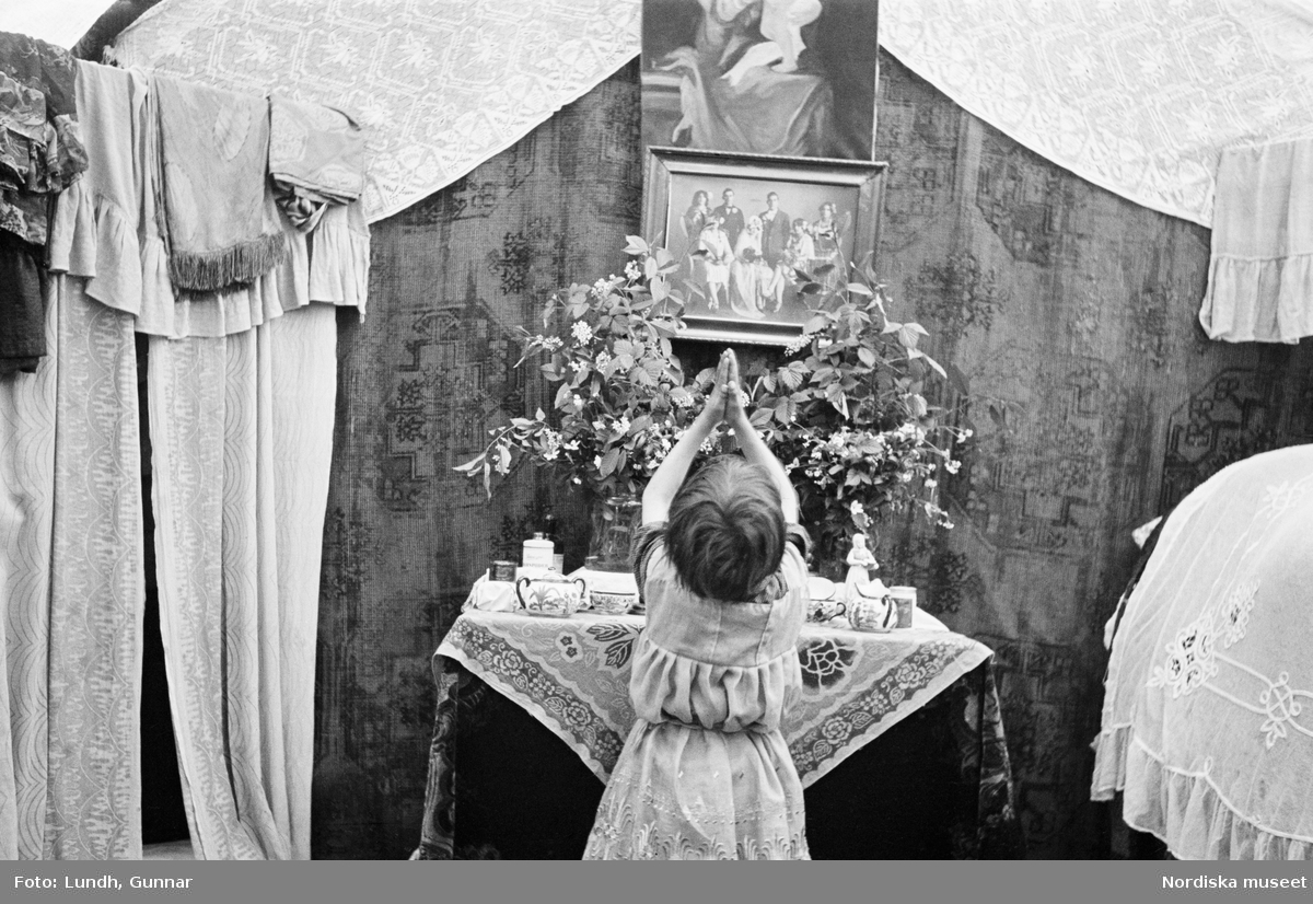 Interiör från familjen Taikons läger vid Johanneshov, södra Stockholm. Liten flicka ber vid familjens altare.
