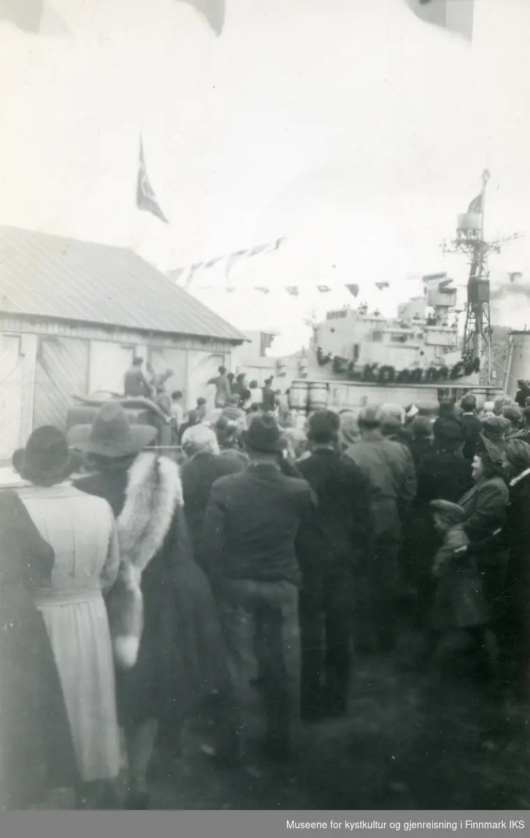 Honningsvåg. Gjenreisning. Besøk av Kong Haakon VII. Folk venter. Jageren "Stord" i bakgrunnen. 09. juli 1946.
