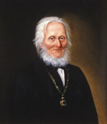 Portrett av Arnoldus v. W. S. Koren. Mørk drakt, medaljong (eller klokke?) i kjede rundt halsen (Foto/Photo)