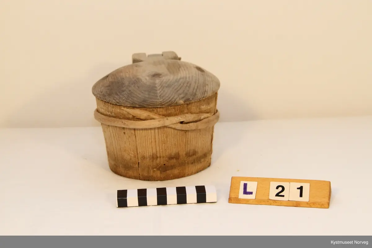 Smørkoppen er brukt til oppbevaring av smør. Treband; to nederst og et øverst. På lokke hank av jerntråd.