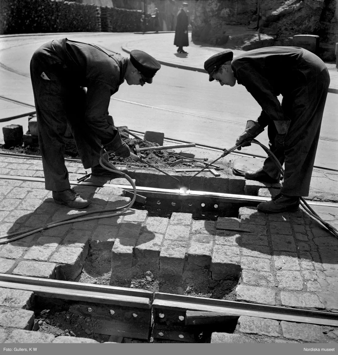 Två spårvägsarbetare svetsar ihop räls. Södermalm, Stockholm