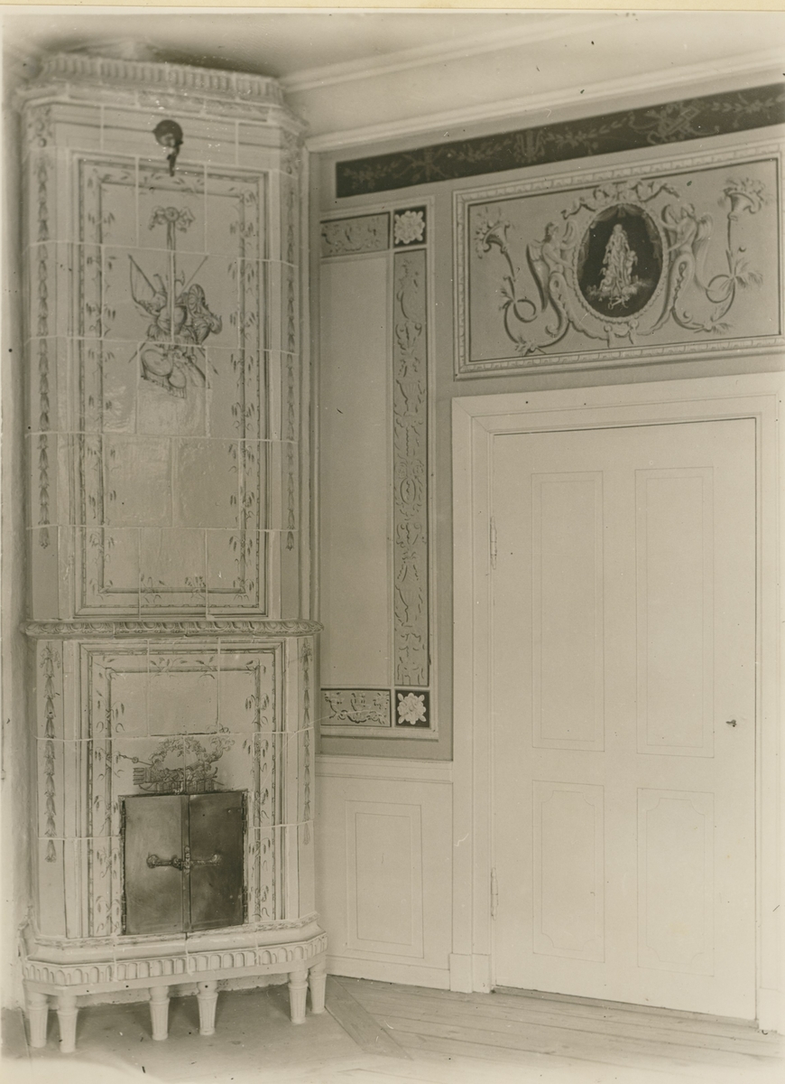 Dekorerad kakelugn och dörröverstycke på övervåningen i Fredriksbergs herrgård.