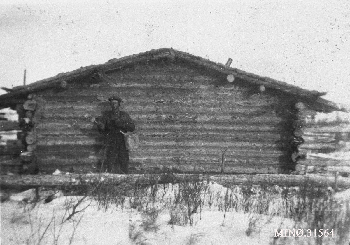 Mann foran hytte