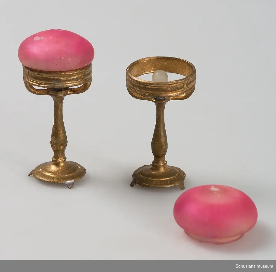 Bordlampor med stativ av obestämbar metall, överdraget med guldbrons, kupa av glas målad med rosa färg, delvis avsliten, glödlampa finns på den ena.