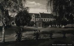 Postkort. Torget  på Folkemuseet med museumsbygninger i bakg