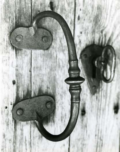 Detaljbild av en dörr med handtag och lås.
