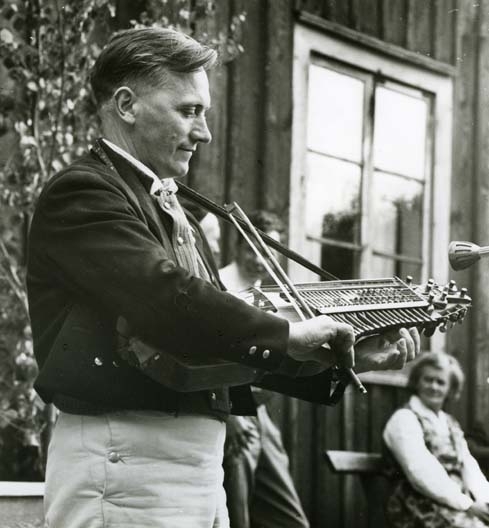 Eric Johan Sahlström när han uppträder med sin nyckelharpa vid hembygdsfesten i Rengsjö 16 juli 1961. Han var riksspelman och nyckelharpspelare.