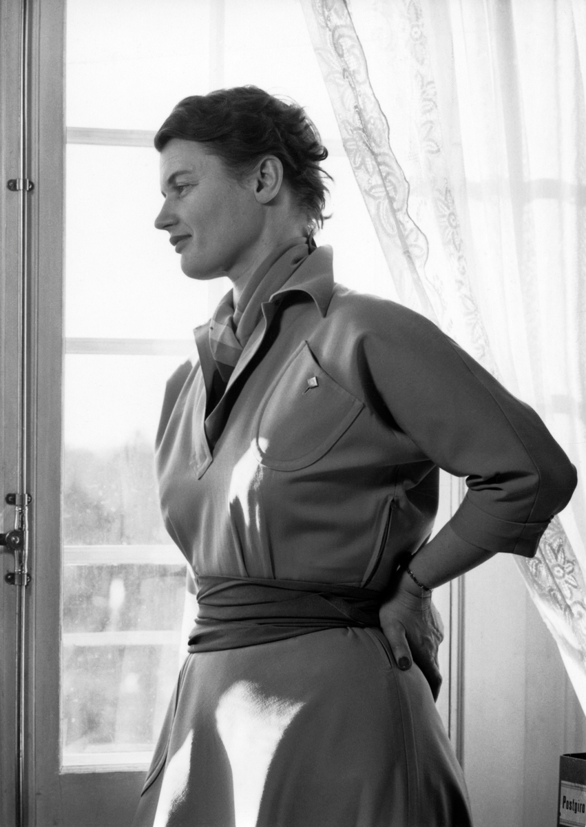Porträtt av fotografen Kerstin Bernhard ståendes vid ett fönster