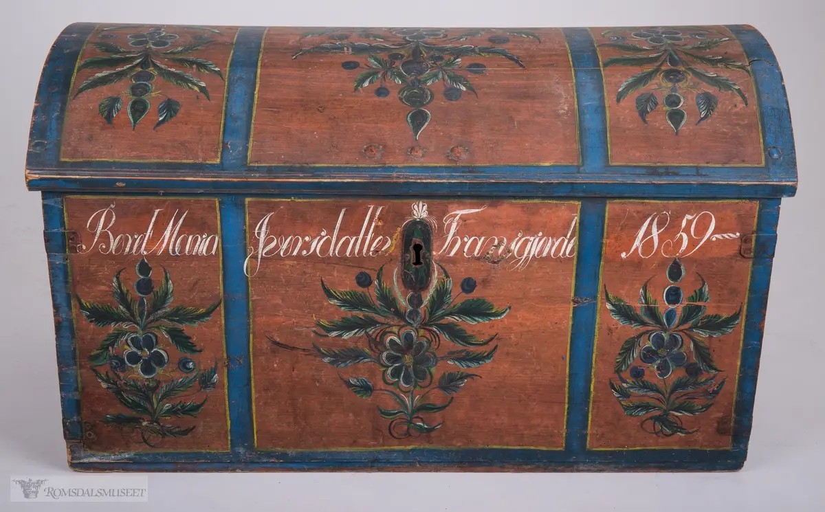 Kisten har oppdelte felt.  Felta er avgrensa med blå og gule kanter. Inne i felta: Rosemalt.  Farger i blått, grønt, gult, hvitt og sort.
Innvendig påtrykt mønster (Påsett farge) i mørkeblått og orange prikker.  Håndtak på hver side.