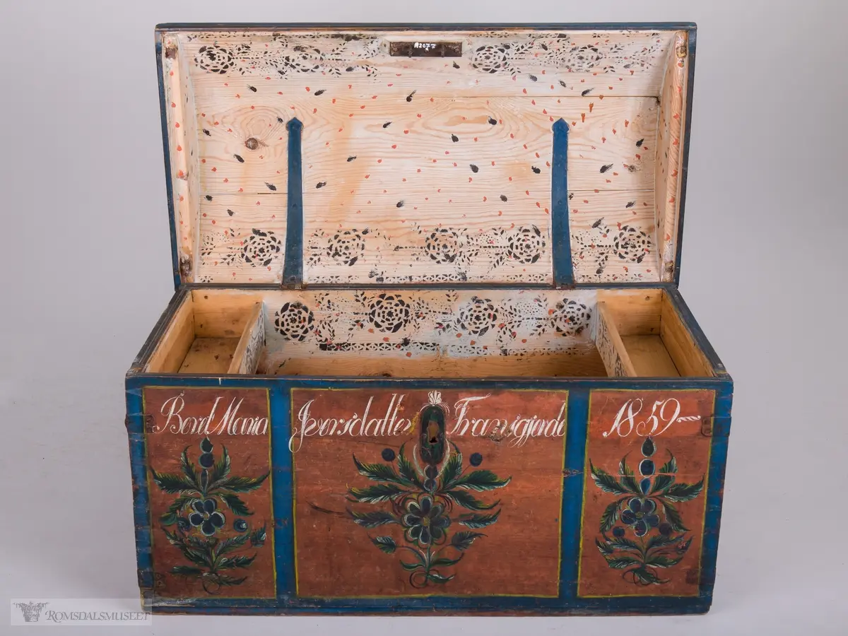 Kisten har oppdelte felt.  Felta er avgrensa med blå og gule kanter. Inne i felta: Rosemalt.  Farger i blått, grønt, gult, hvitt og sort.
Innvendig påtrykt mønster (Påsett farge) i mørkeblått og orange prikker.  Håndtak på hver side.