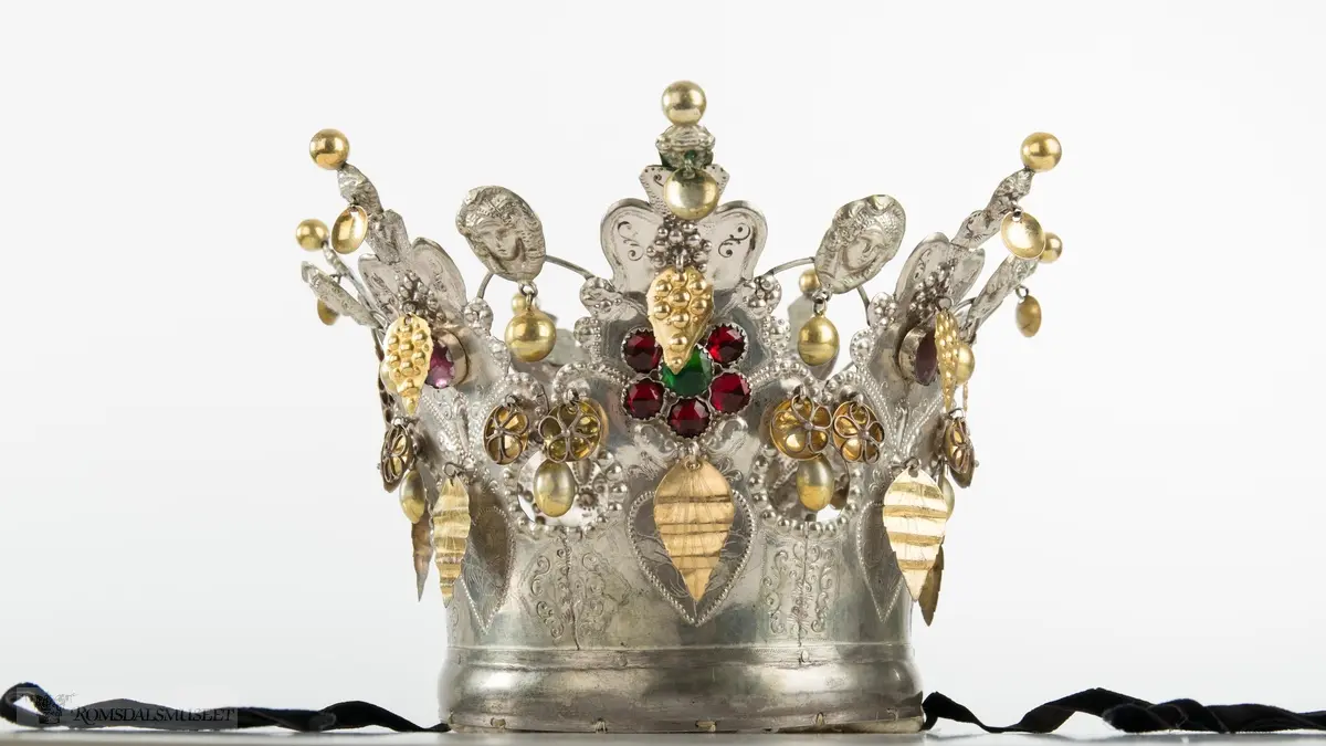 På bøylen mellom delene er loddet på et hode. Hjerte med blomst og blad på hver del.