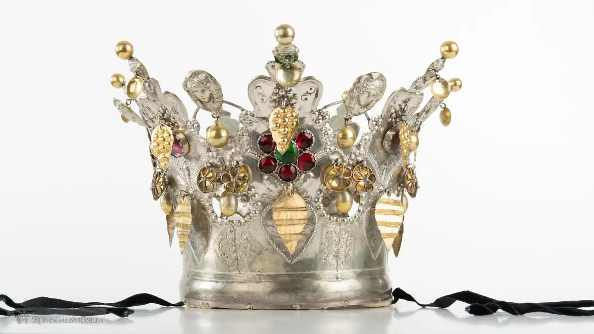 På bøylen mellom delene er loddet på et hode. Hjerte med blomst og blad på hver del.