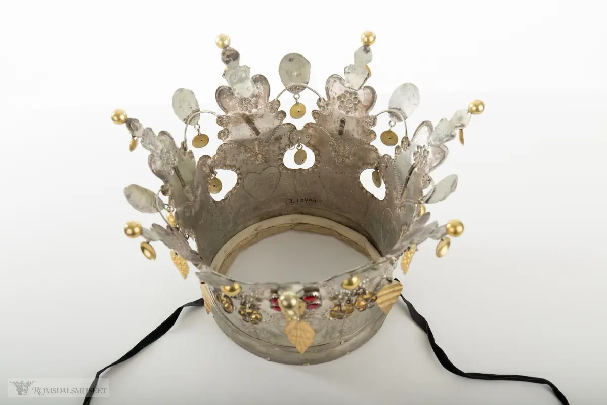 På bøylen mellom delene er loddet på et hode. Hjerte med blomst og blad på hver del.