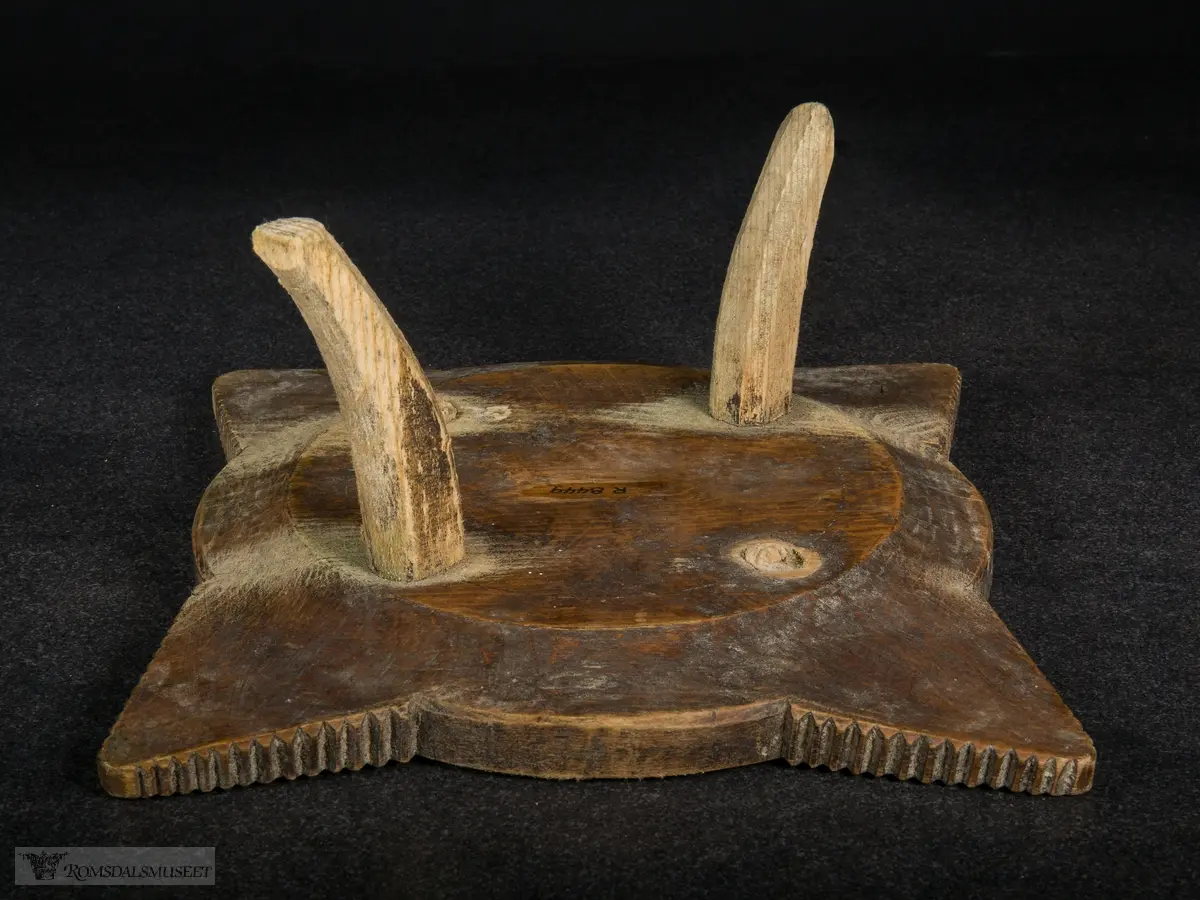 Utskjæring på fatet, små spisser i sirkler og på vinger. Ringene som omkranser midten minner om tannhjul.