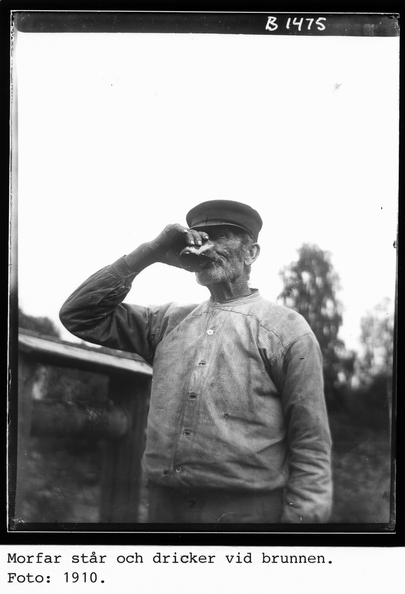Morfar, Jonas Larsson ("Furbo Jon"), står och dricker vid brunnen. Foto 1910.
