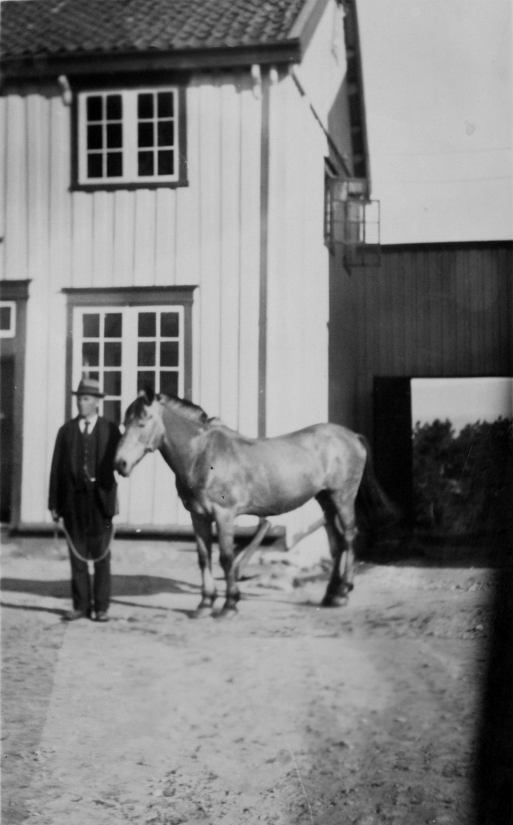 Tidligere forpakter (Haugen) på gården. Han står foran Wesselbygningen med en hest.