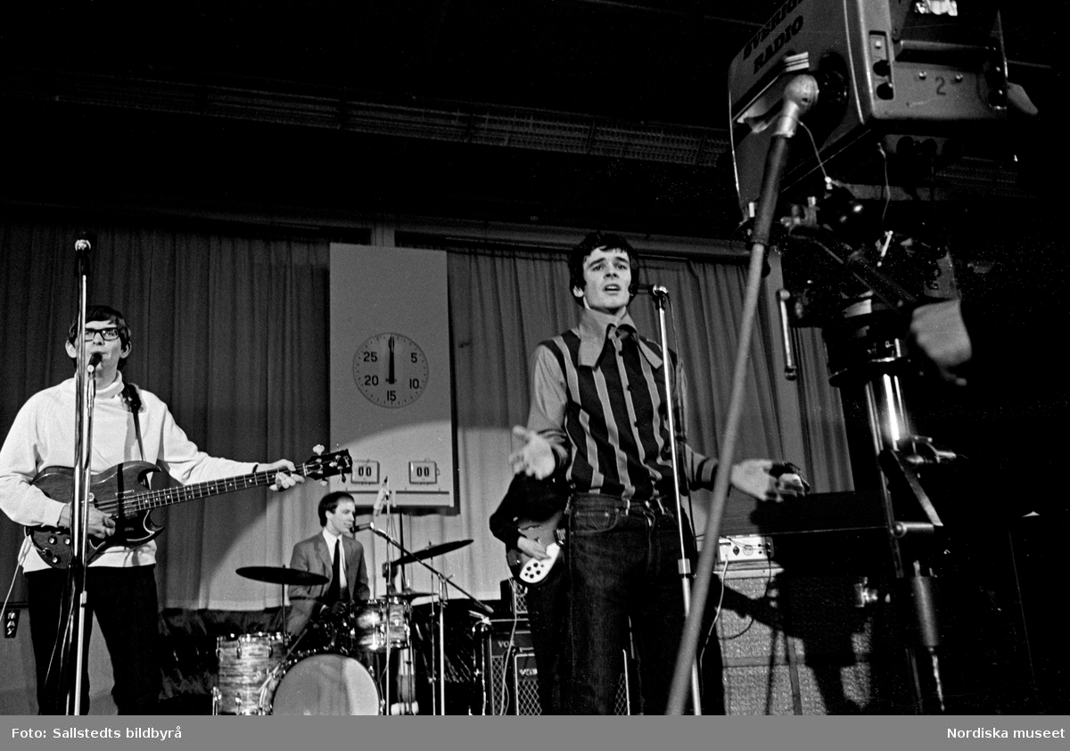 Den brittiska popgruppen The Zombies uppträder på TV-programmet Drop-In 1966. Framför scenen en tv-kamera.