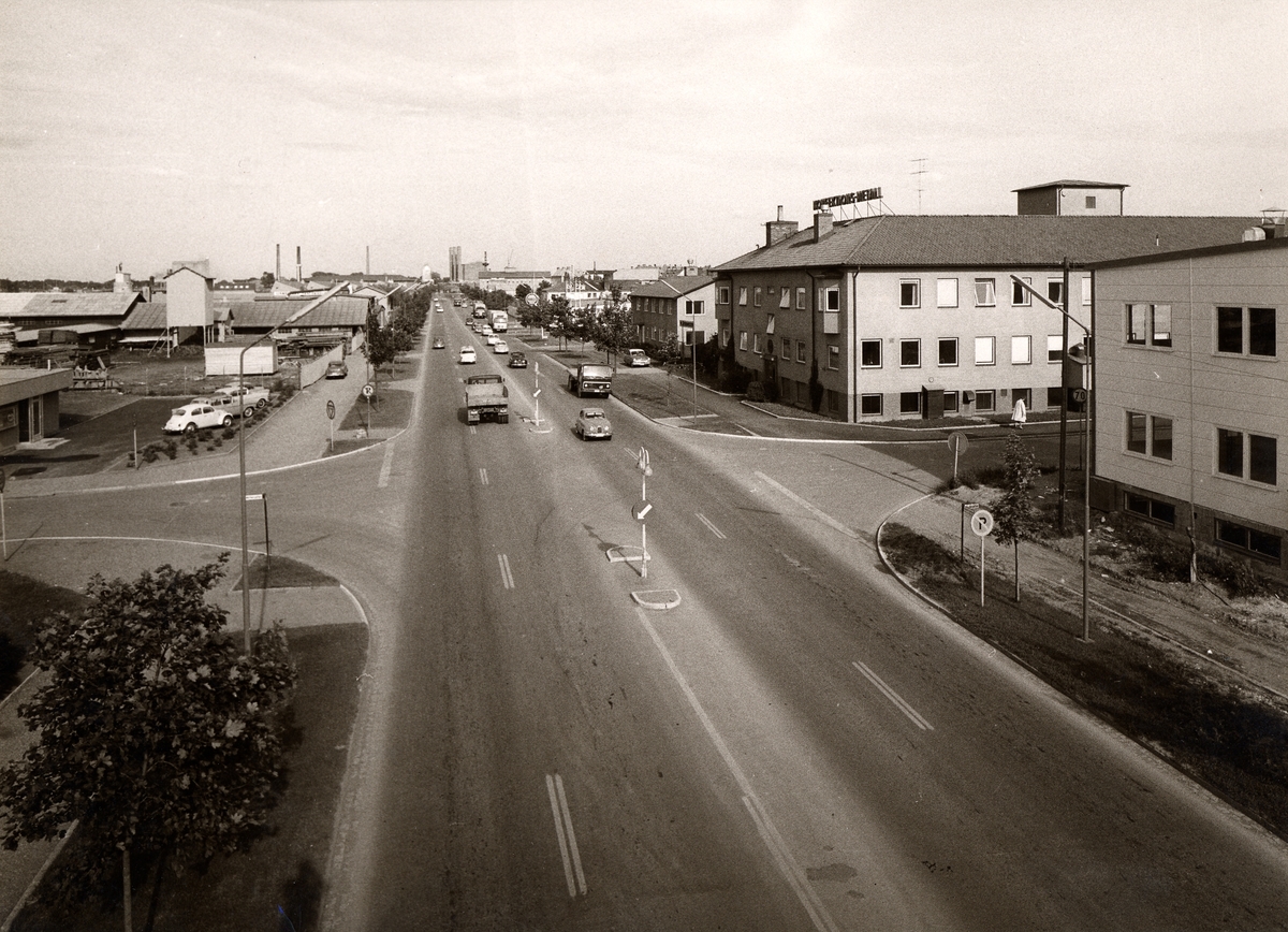 Orig. text: Industrigatan 1967. Vänstertrafik
Stora byggnaden på höger sida är Konfektions-Metall. Vid korsningen Industrigatan/Mellangatan.